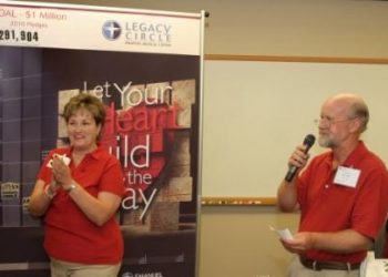 Susan Quigley, community fund drive divisional leader, and Bill Gibbs, community fund drive chair, announce Thursday night’s results at Legacy Circle of Emanuel’s weekly report session.