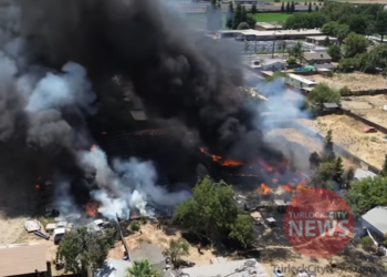 Two Firefighters Injured After Blaze Damages 23 Vehicles and Outbuilding